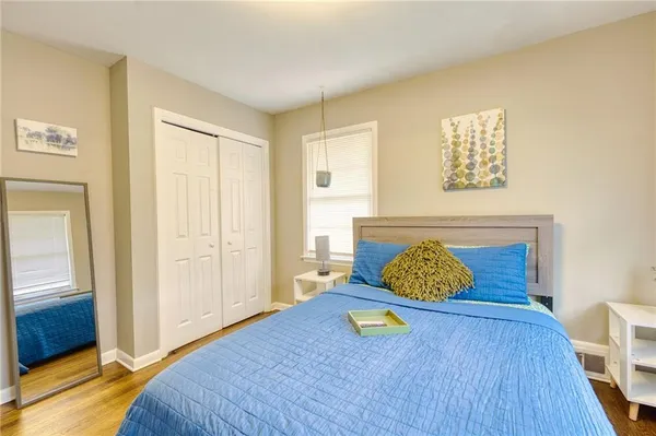 a bedroom with a bed and wooden floor