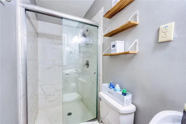 a bathroom with a shower toilet and sink