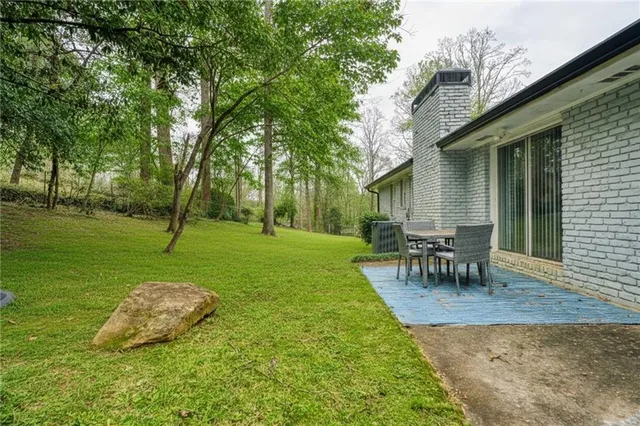a view of a house with a yard and hanging chair