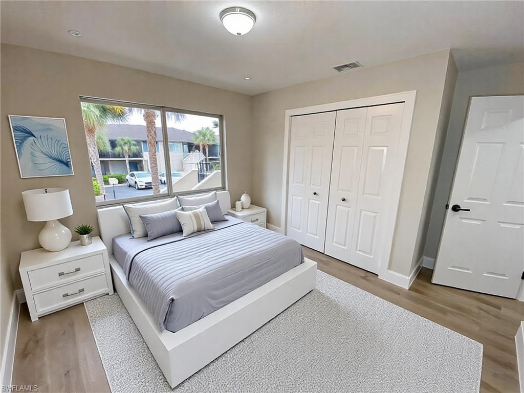 4180 Looking Glass Lane, Unit 4108 Naples, FL 34112 - Photo 13 of 21 Bedroom with a closet, visible vents, baseboards, and light wood finished floors