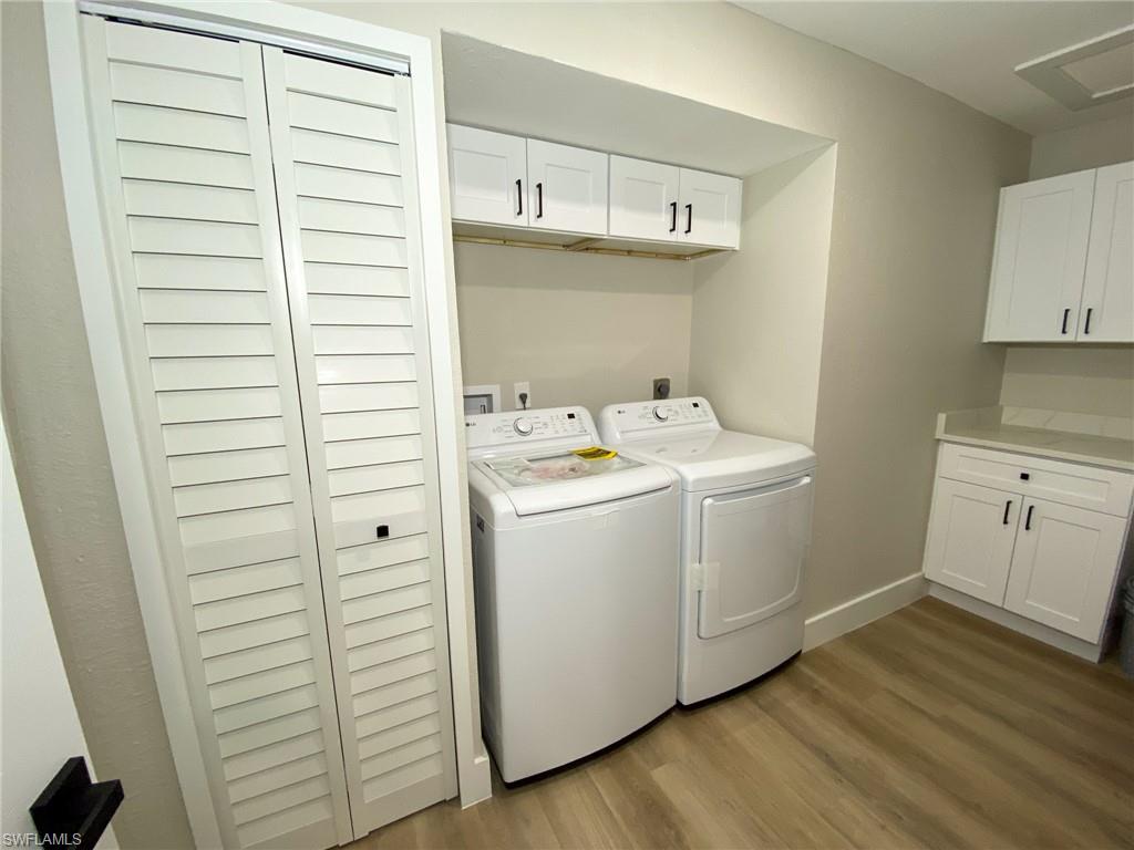 4180 Looking Glass Lane, Unit 4108 Naples, FL 34112 - Photo 16 of 21 Clothes washing area featuring baseboards, washing machine and dryer, cabinet space, and light wood-style floors