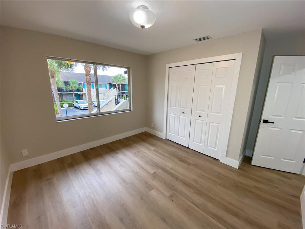 4180 Looking Glass Lane, Unit 4108 Naples, FL 34112 - Photo 17 of 21 Unfurnished bedroom with wood finished floors, visible vents, and baseboards