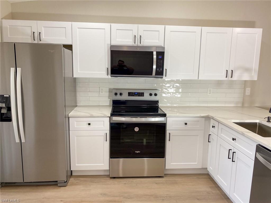 4180 Looking Glass Lane, Unit 4108 Naples, FL 34112 - Photo 4 of 21 Kitchen with appliances with stainless steel finishes and white cabinets
