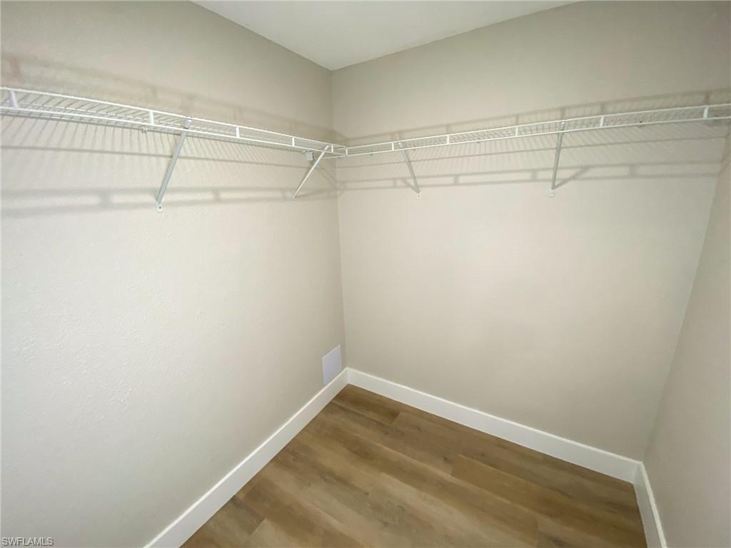 4180 Looking Glass Lane, Unit 4108 Naples, FL 34112 - Photo 9 of 21 Walk in closet with visible vents and wood finished floors