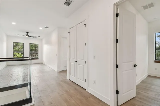 a view of a hallway with wooden floor and staircase