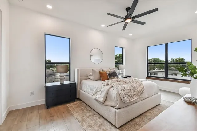 a bedroom with a large bed and a chandelier fan