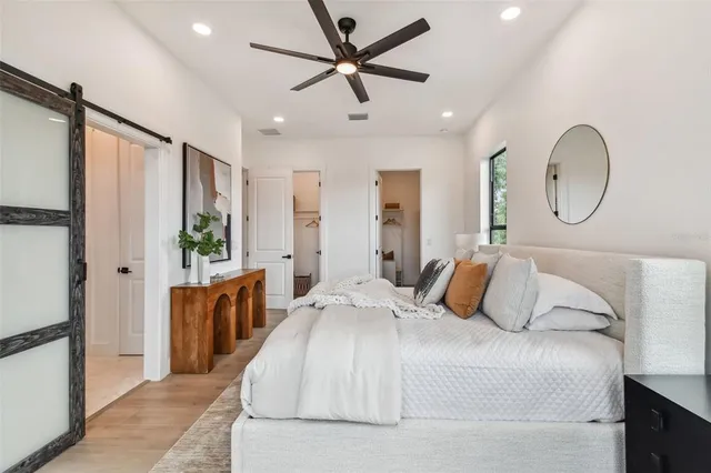 a bedroom with a large bed and a chandelier