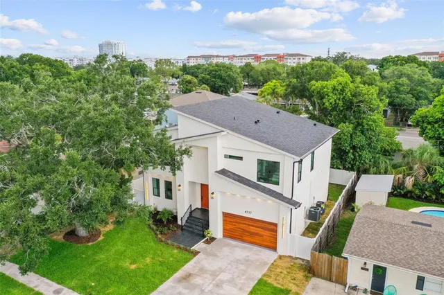 an aerial view of residential houses with outdoor space and swimming pool