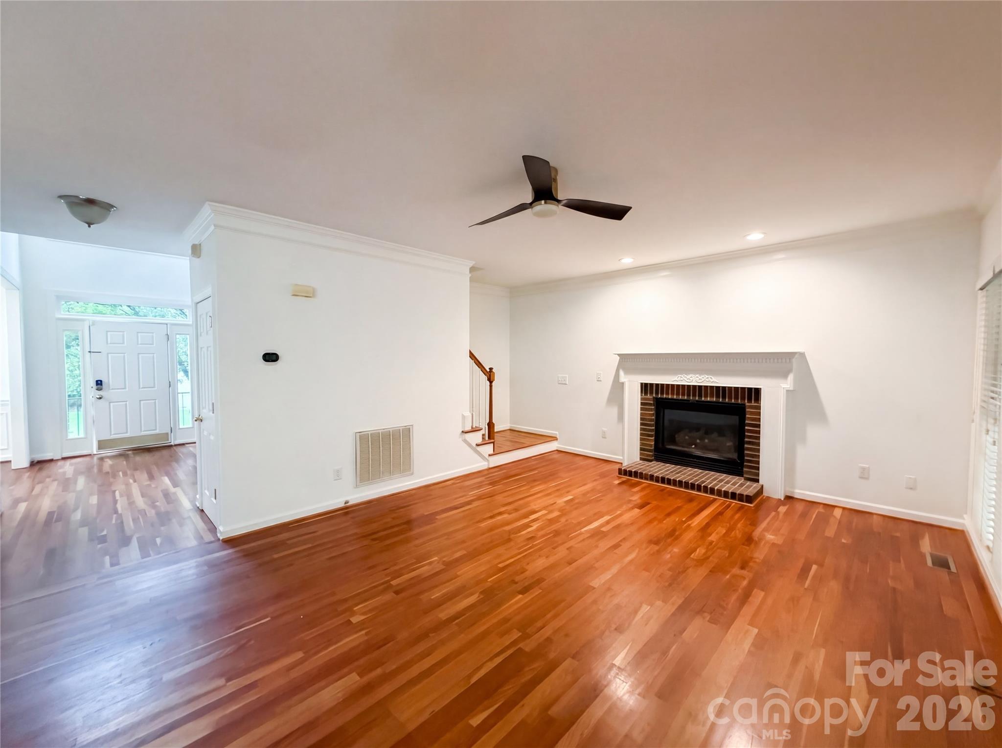 12341 Willingdon Road Huntersville, NC 28078 - Photo 3 of 17 a view of empty room with wooden floor and fireplace