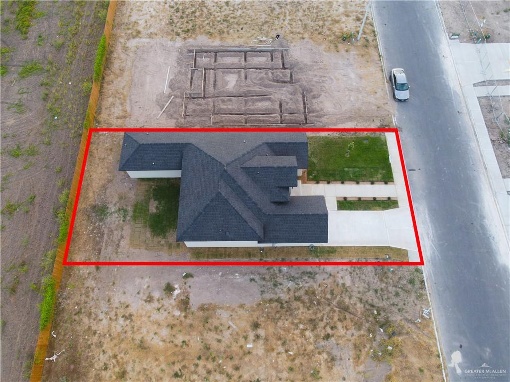 431 Sandy Road Donna, TX 78537 - Photo 24 of 28 Dark shingled roof, white exterior walls, concrete driveway, front yard with grass, concrete sidewalk