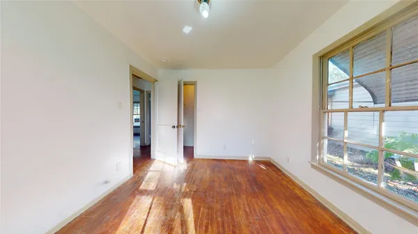 a view of a room with wooden floor and a window