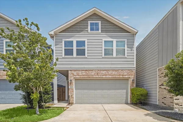 a front view of a house with a garden and garage