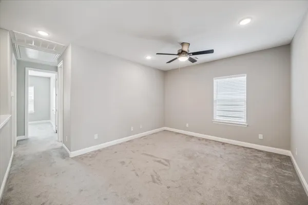 an empty room with ceiling fan and window