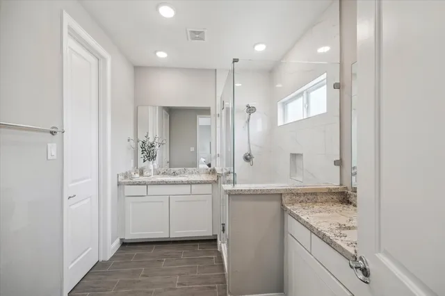 a bathroom with a granite countertop sink mirror and double