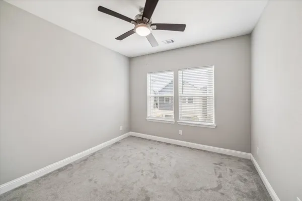 an empty room with a window and a fan