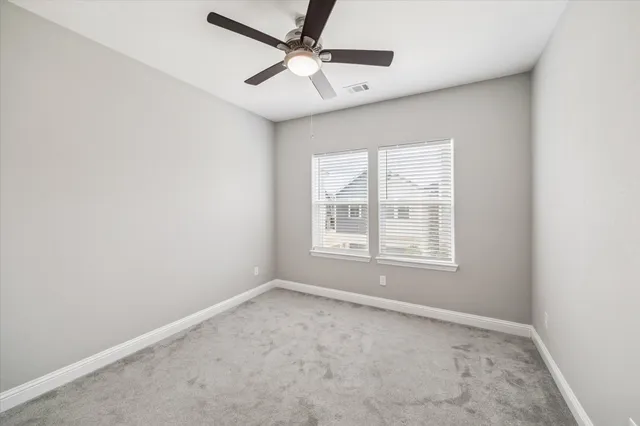 an empty room with a window and a fan