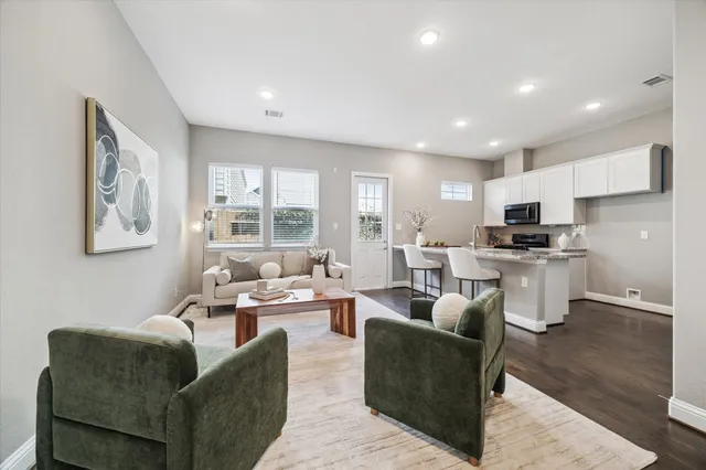 a living room with furniture and kitchen view