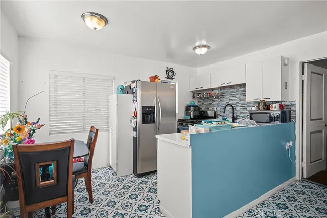 a kitchen with stainless steel appliances wooden floor and a refrigerator
