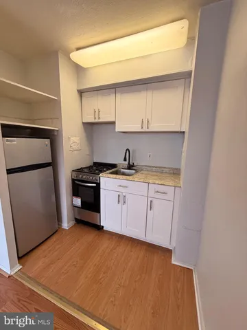 a kitchen with a sink a refrigerator and cabinets