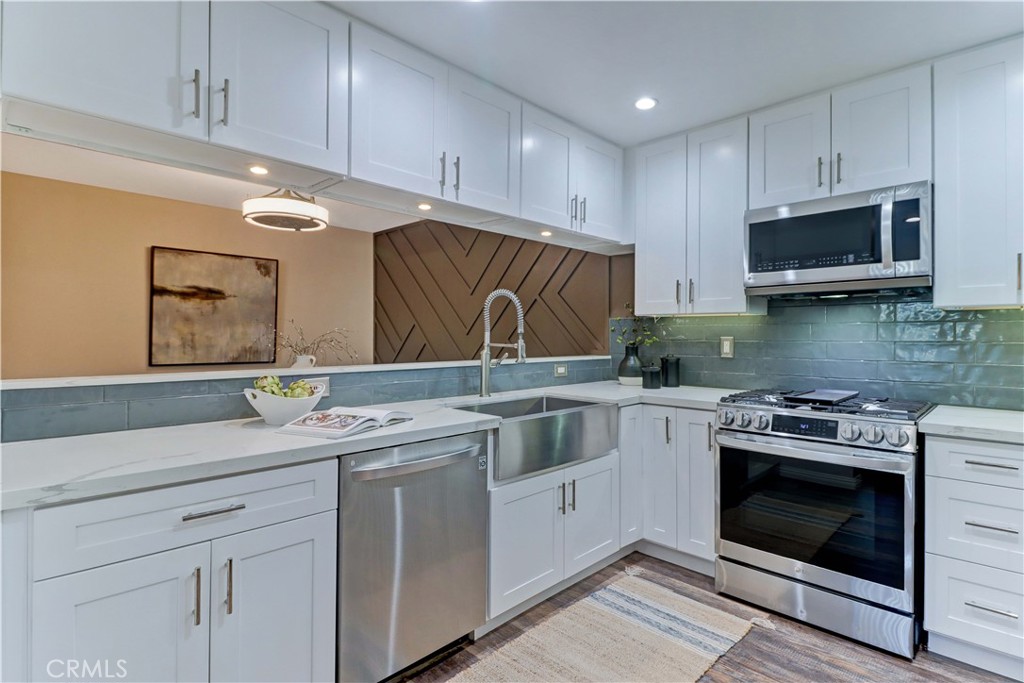 3605 East Anaheim Street, Unit 102 Long Beach, CA 90804 - Photo 11 of 37 a kitchen with cabinets stainless steel appliances a sink and a stove