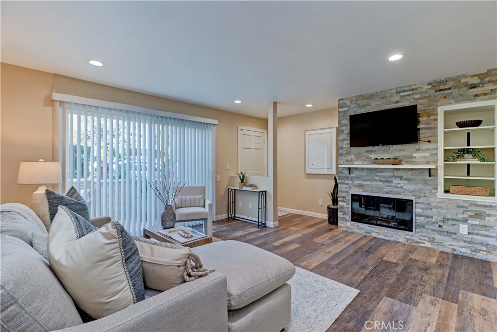 3605 East Anaheim Street, Unit 102 Long Beach, CA 90804 - Photo 2 of 37 a living room with furniture a fireplace and a flat screen tv