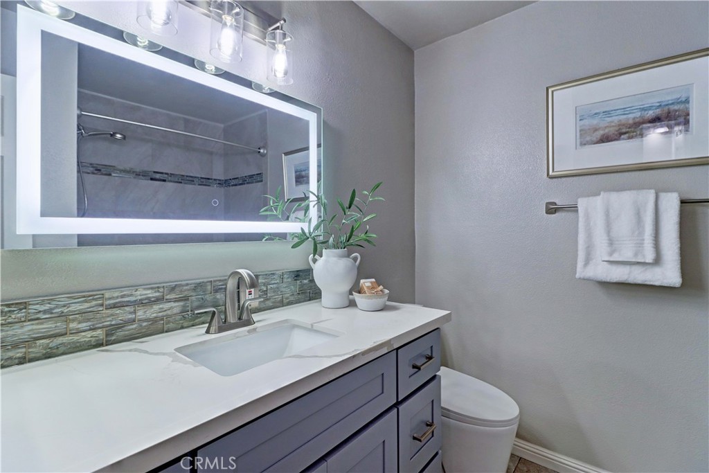 3605 East Anaheim Street, Unit 102 Long Beach, CA 90804 - Photo 28 of 37 a bathroom with a granite countertop sink and a toilet