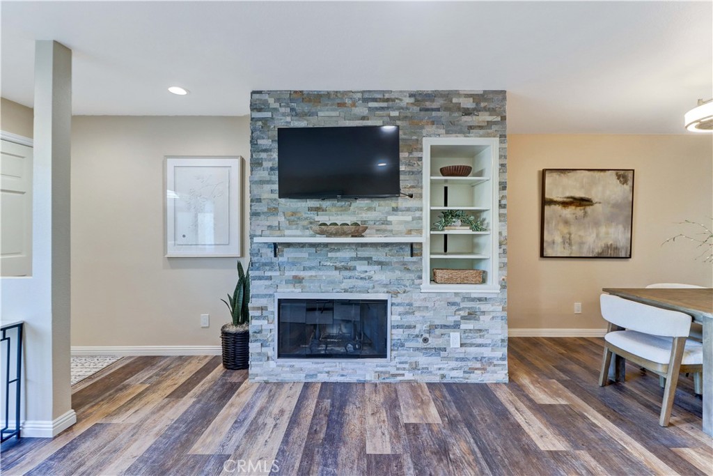 3605 East Anaheim Street, Unit 102 Long Beach, CA 90804 - Photo 5 of 37 a living room with a fireplace and a flat screen tv