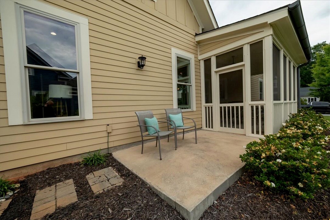 217 Pershing Avenue Clemson, SC 29631 - Photo 24 of 37 A private concrete patio extends from the screened porch, bordered by landscaping.