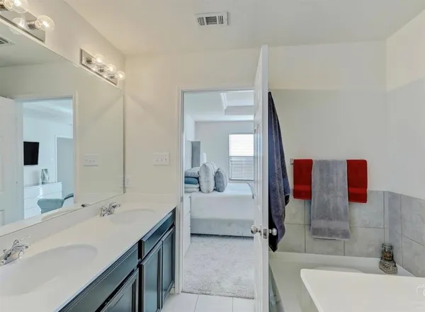 a bathroom with a tub sink and mirror