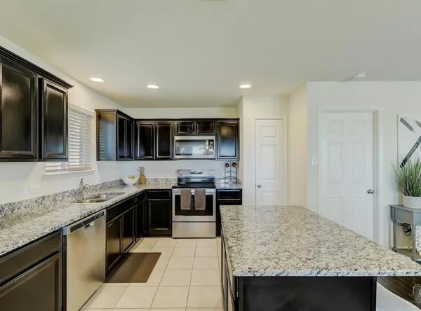 a kitchen with stainless steel appliances granite countertop a sink and stove top oven