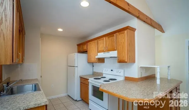 a kitchen with a stove a sink a refrigerator and a counter top space