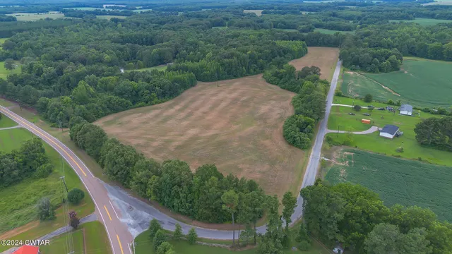 an aerial view of a house with a yard and lake view