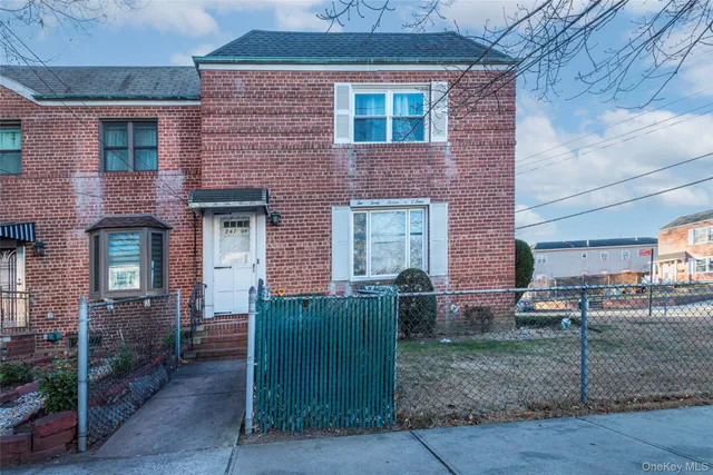 a view of a brick house many windows and a yard