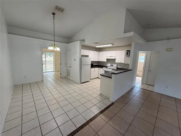 a kitchen with stainless steel appliances kitchen island granite countertop a refrigerator and a stove top oven