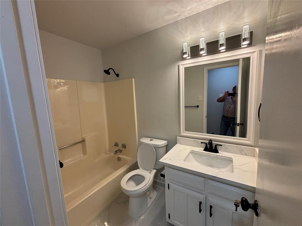 8455 Sugarberry Road Dallas, TX 75249 - Photo 14 of 18 a bathroom with a sink a toilet and shower