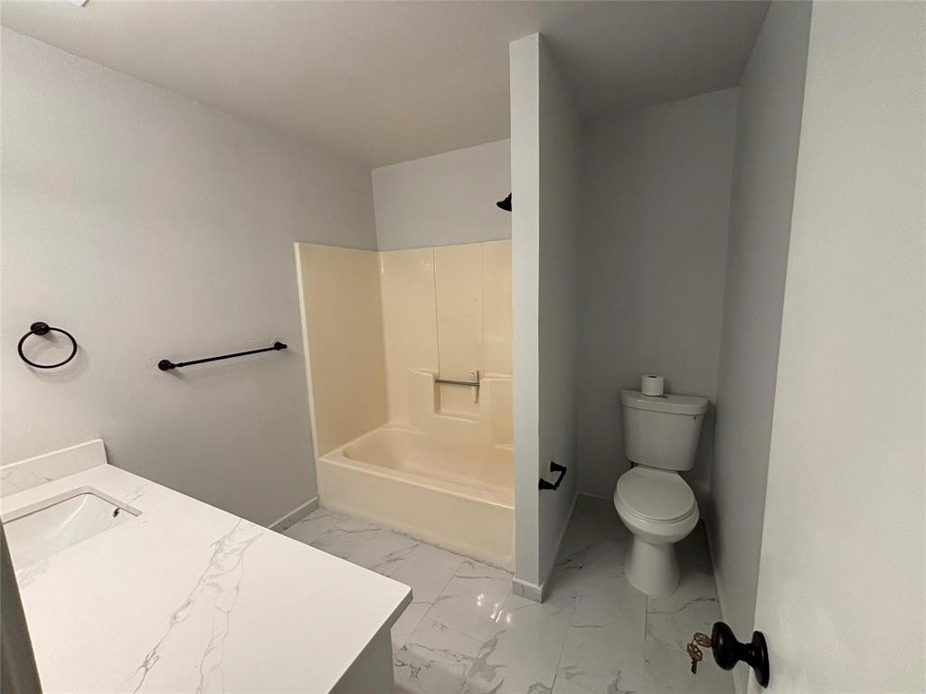 8455 Sugarberry Road Dallas, TX 75249 - Photo 15 of 18 a bathroom with a sink a toilet and shower