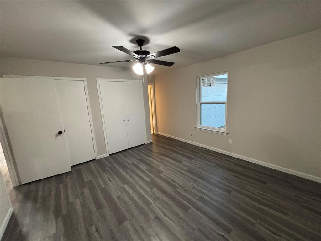 8455 Sugarberry Road Dallas, TX 75249 - Photo 5 of 18 an empty room with wooden floor fan and windows