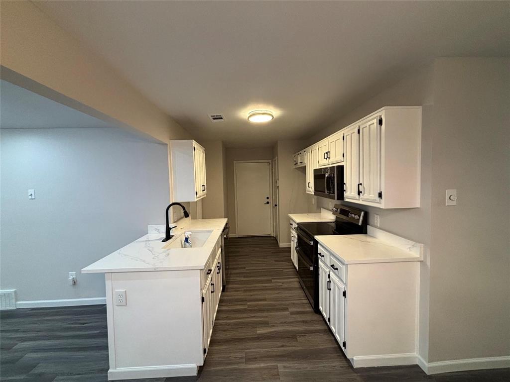 8455 Sugarberry Road Dallas, TX 75249 - Photo 7 of 18 a room with stainless steel appliances a white stove top oven and a white refrigerator