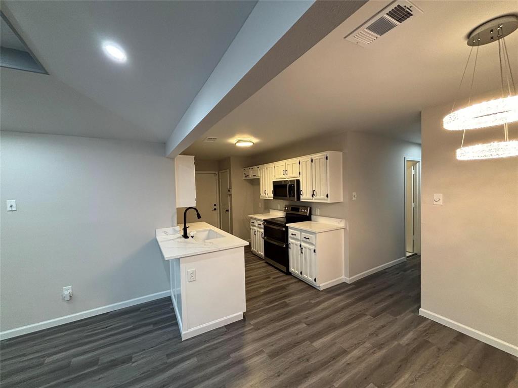 8455 Sugarberry Road Dallas, TX 75249 - Photo 8 of 18 a kitchen with a sink cabinets and wooden floor