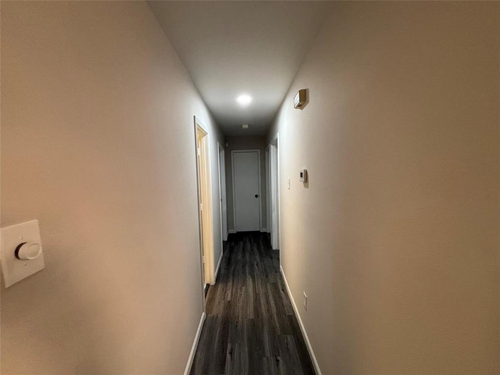 8455 Sugarberry Road Dallas, TX 75249 - Photo 9 of 18 a view of a hallway with wooden floor