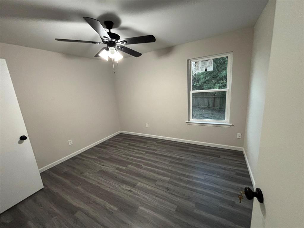 8455 Sugarberry Road Dallas, TX 75249 - Photo 10 of 18 an empty room with wooden floor fan and windows