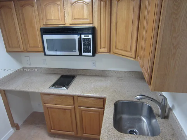a kitchen with granite countertop white cabinets and sink