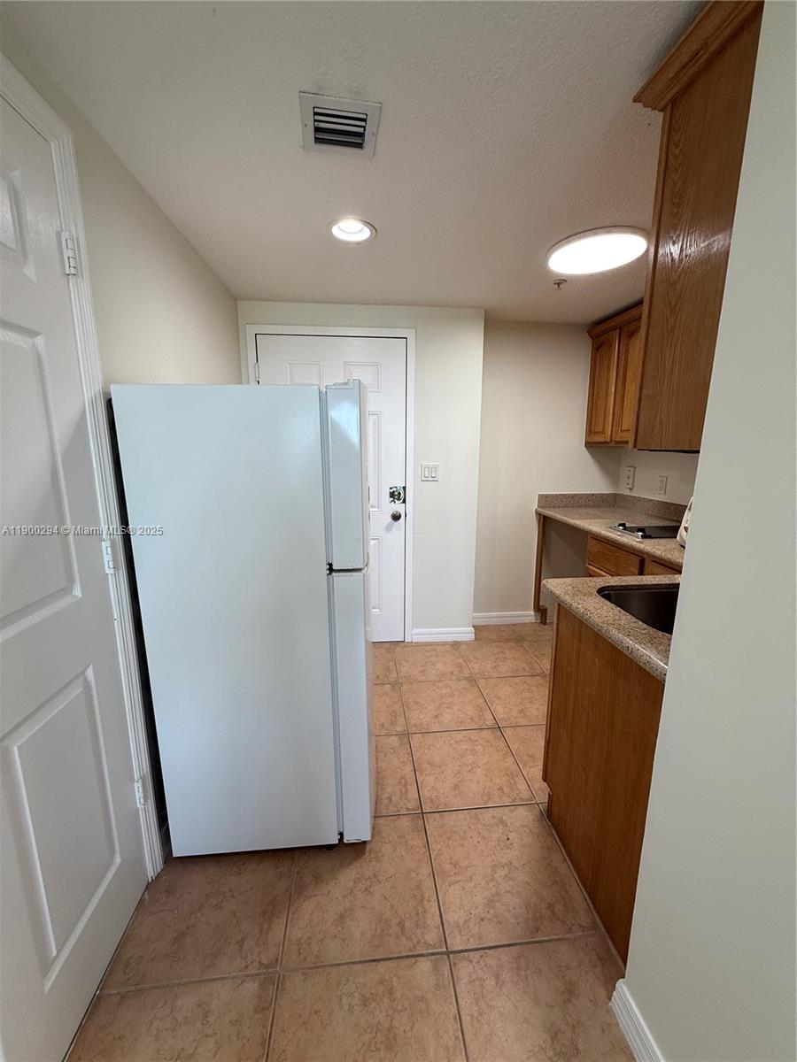 4242 Northwest 2nd Street, Unit 1613 Miami, FL 33126 - Photo 13 of 30 a view of a storage & utility room with a stove fridge