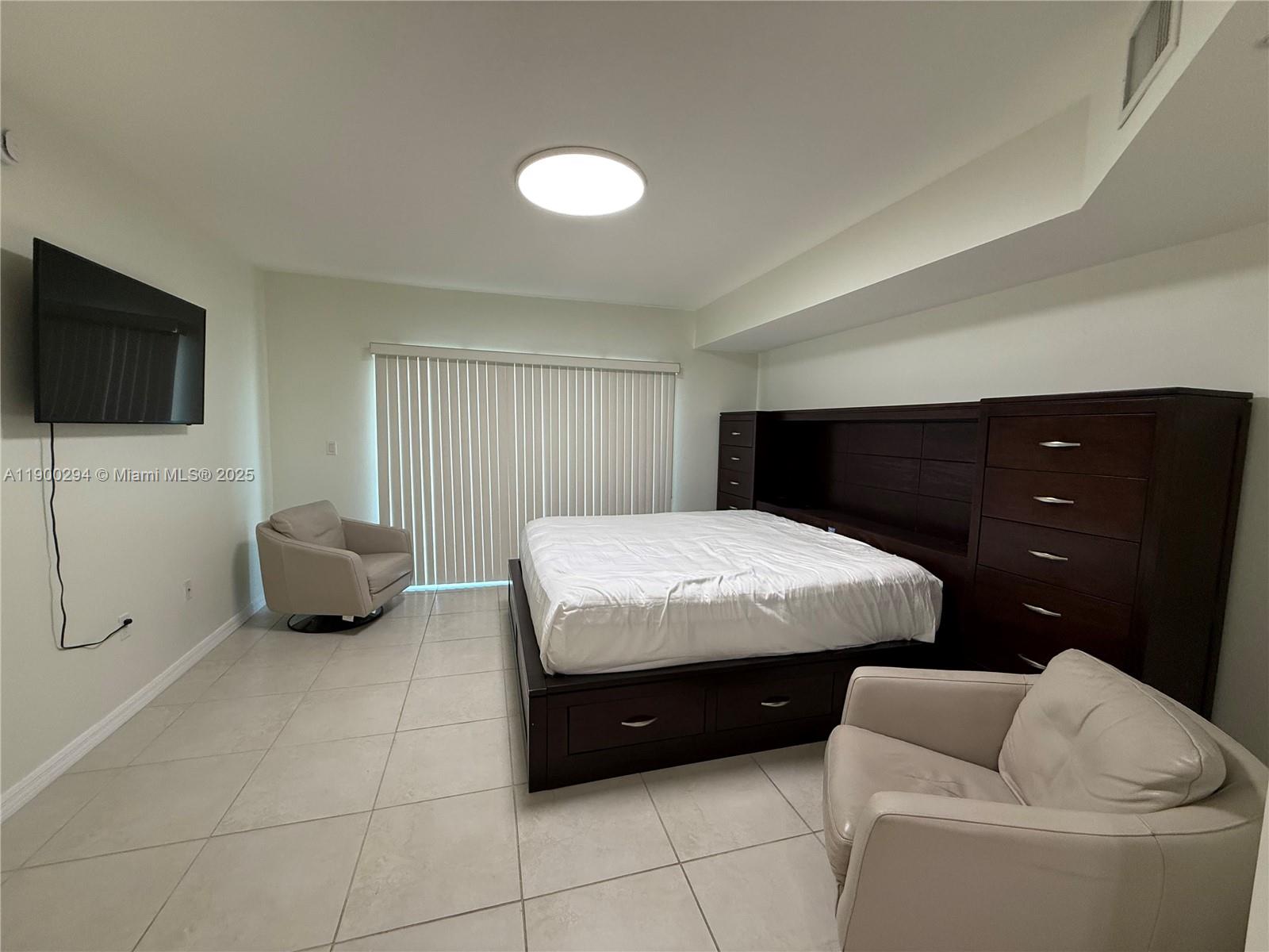 4242 Northwest 2nd Street, Unit 1613 Miami, FL 33126 - Photo 3 of 30 a bedroom with a bed and a television