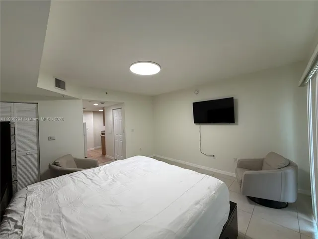a bedroom with a bed and a flat screen tv