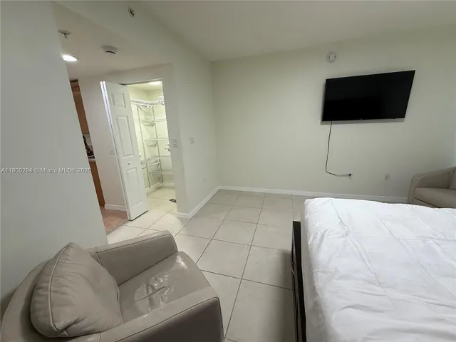 a bedroom with a bed and a flat screen tv