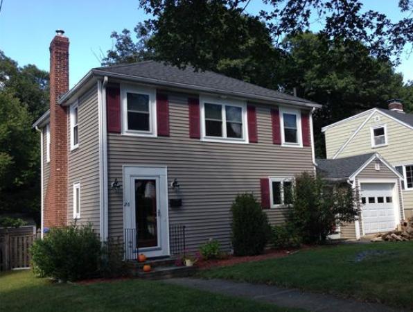 a front view of a house with a yard and trees