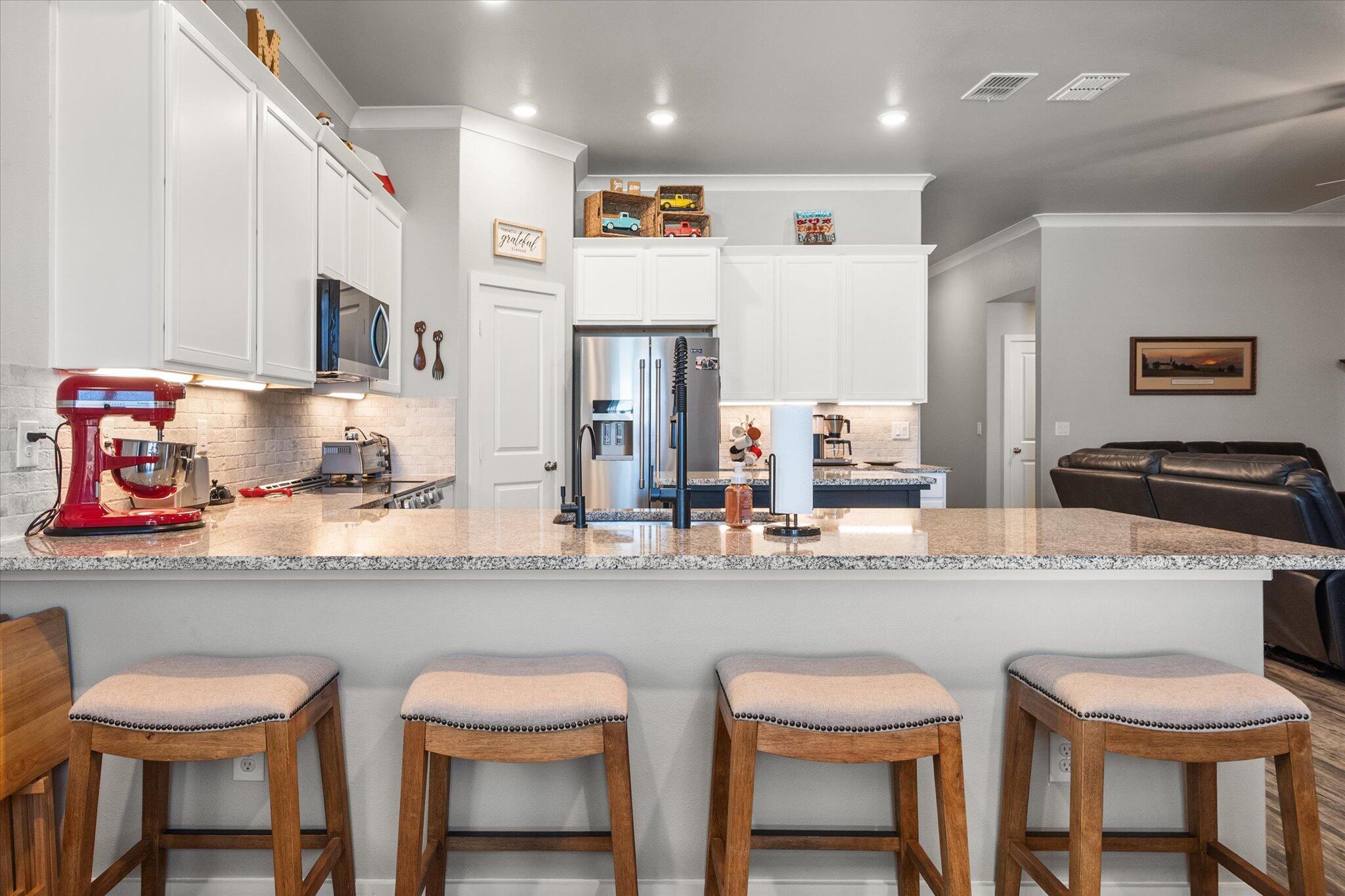 2010 142nd Street Lubbock, TX 79423 - Photo 23 of 33 a kitchen with granite countertop cabinets and chair