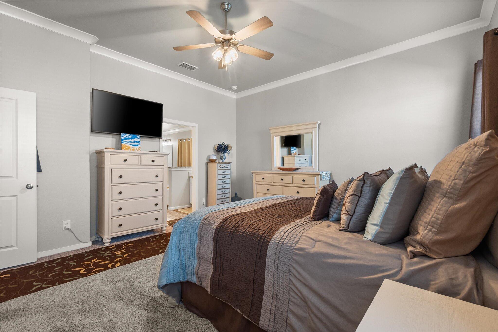 2010 142nd Street Lubbock, TX 79423 - Photo 25 of 33 a bedroom with a bed a flat screen tv and a chandelier