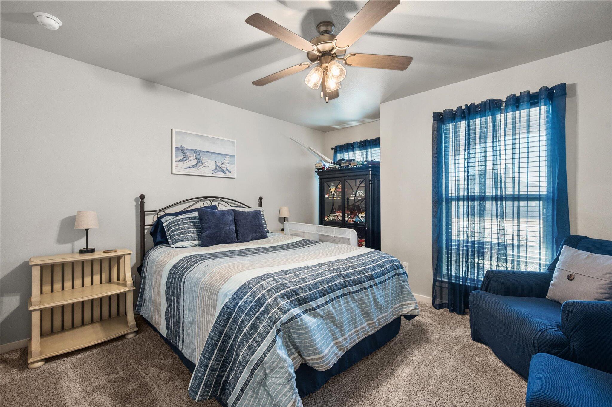 2010 142nd Street Lubbock, TX 79423 - Photo 7 of 33 a bedroom with a bed couch and a large window